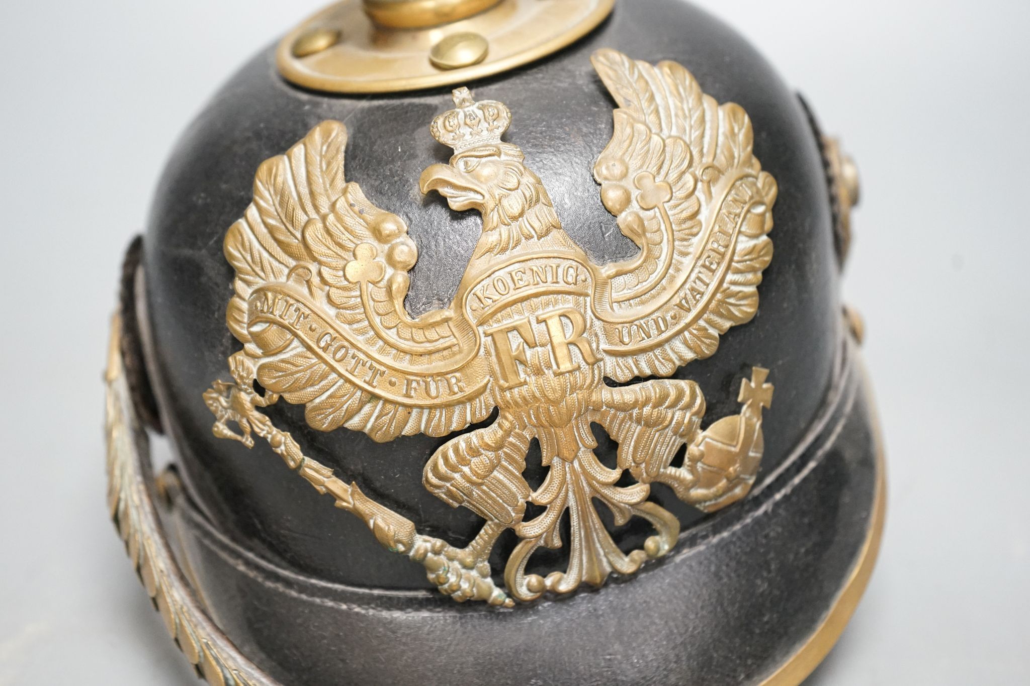 A WW1 Prussian pickelhaube, the leather skull with brass spiked top and eagle plate